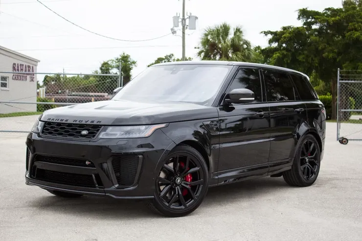 A black range rover sport is parked in a parking lot.