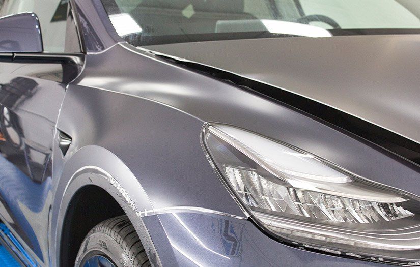 A close up of a tesla model y 's headlight and fender.