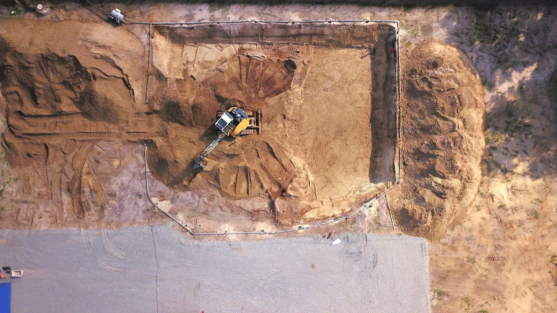 An aerial view of a construction site with a bulldozer moving dirt.