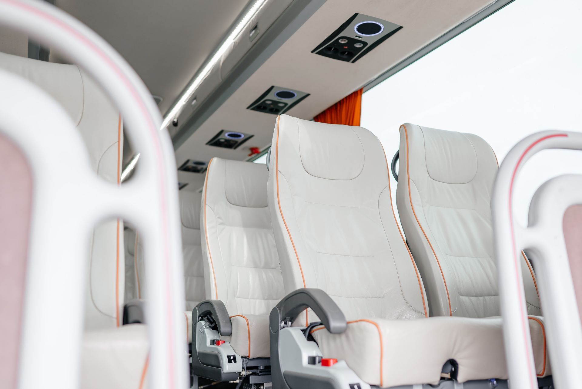 Interior view of a modern passenger bus showing rows of comfortable, upholstered seats.