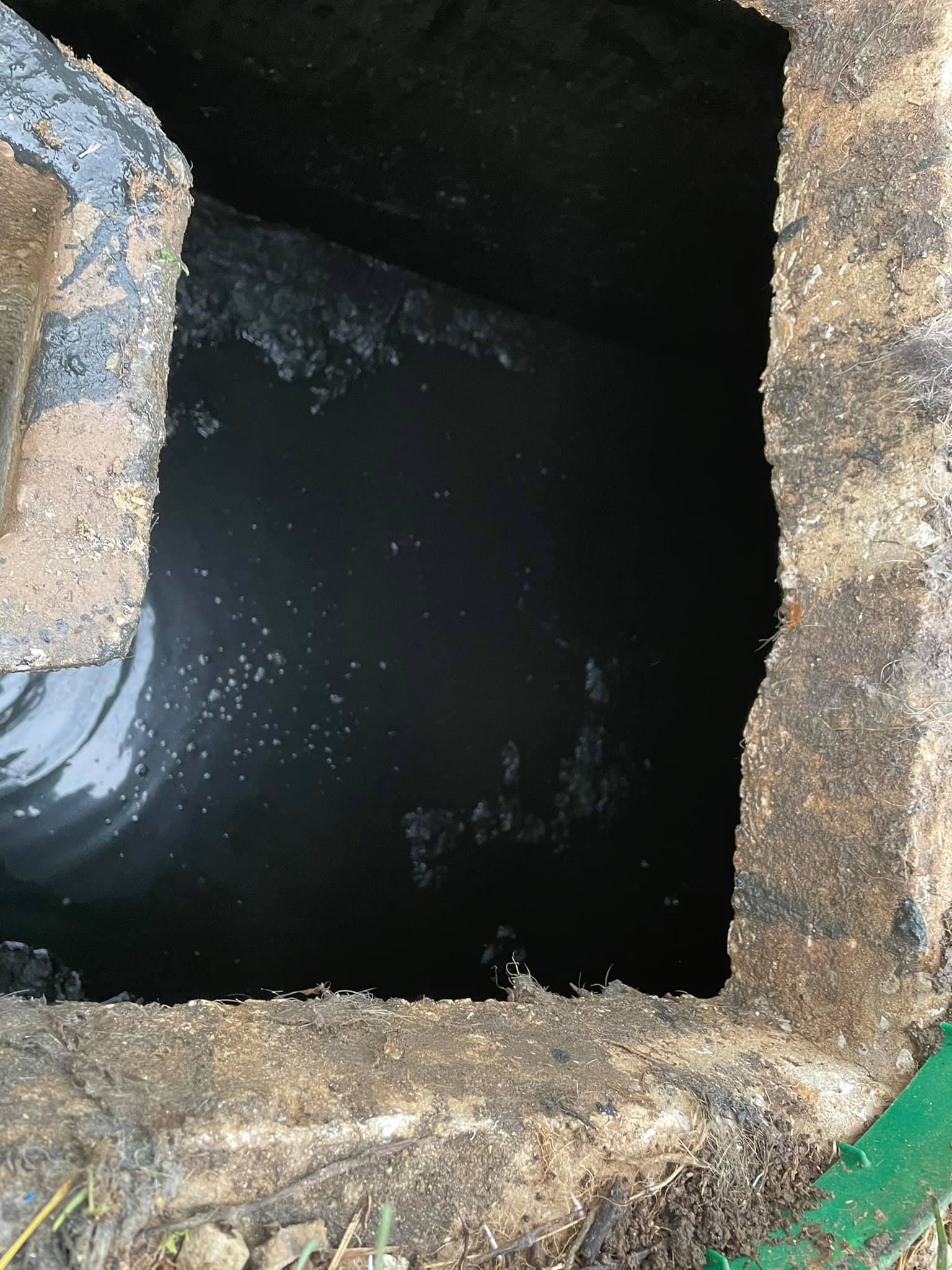 A hole in the ground with a pipe coming out of it.