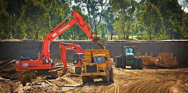 A group of construction vehicles are working on a construction site.