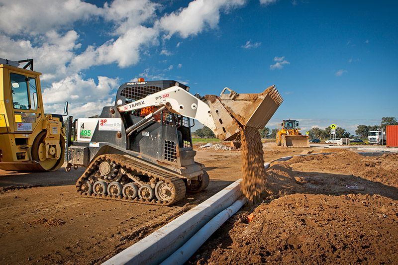 A bulldozer is loading dirt into a bucket on a construction site.