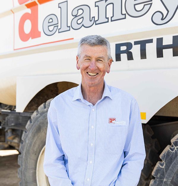 A man standing in front of a delancy truck
