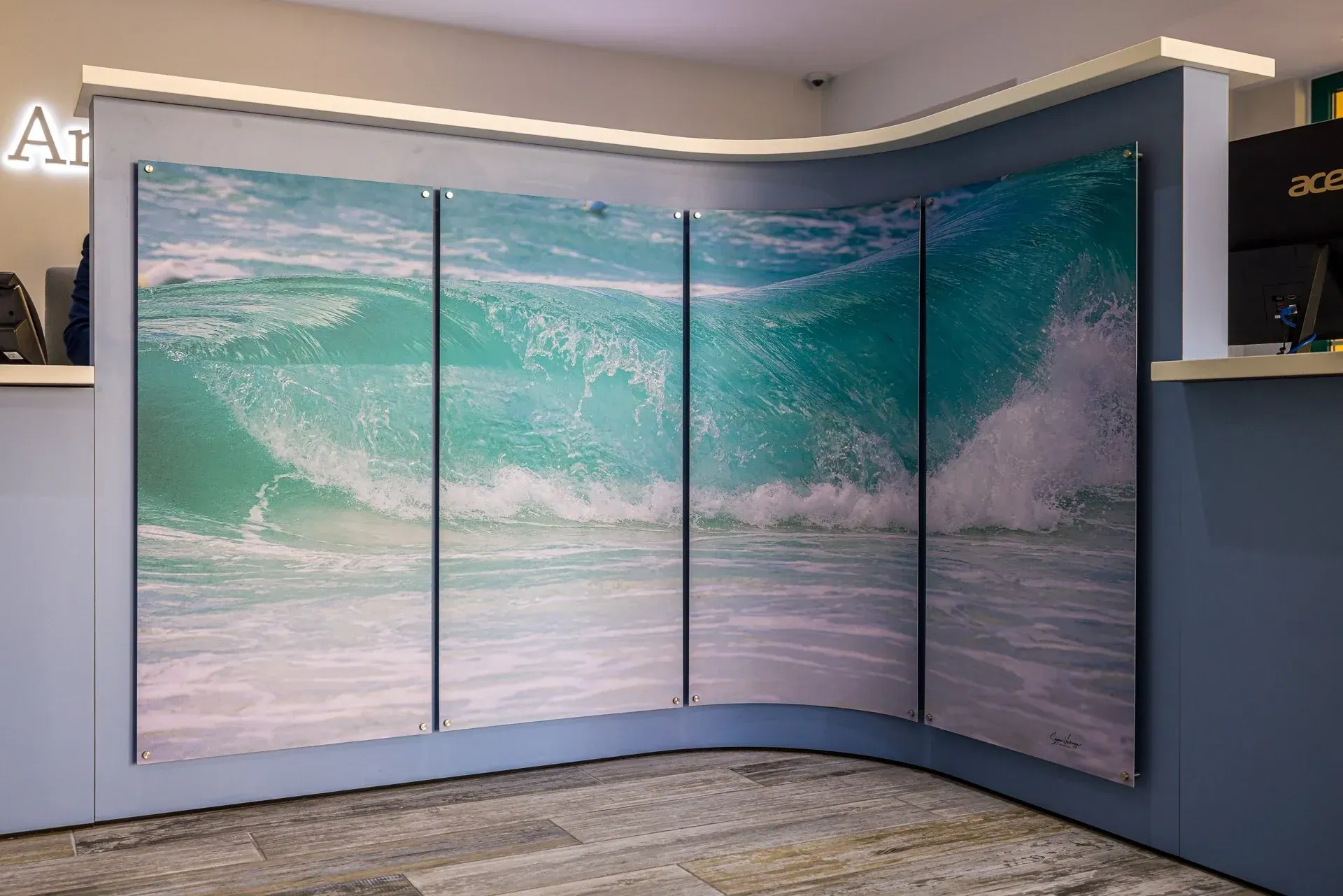 Ocean-wave Duraluxe metal panels installed across a curved reception desk