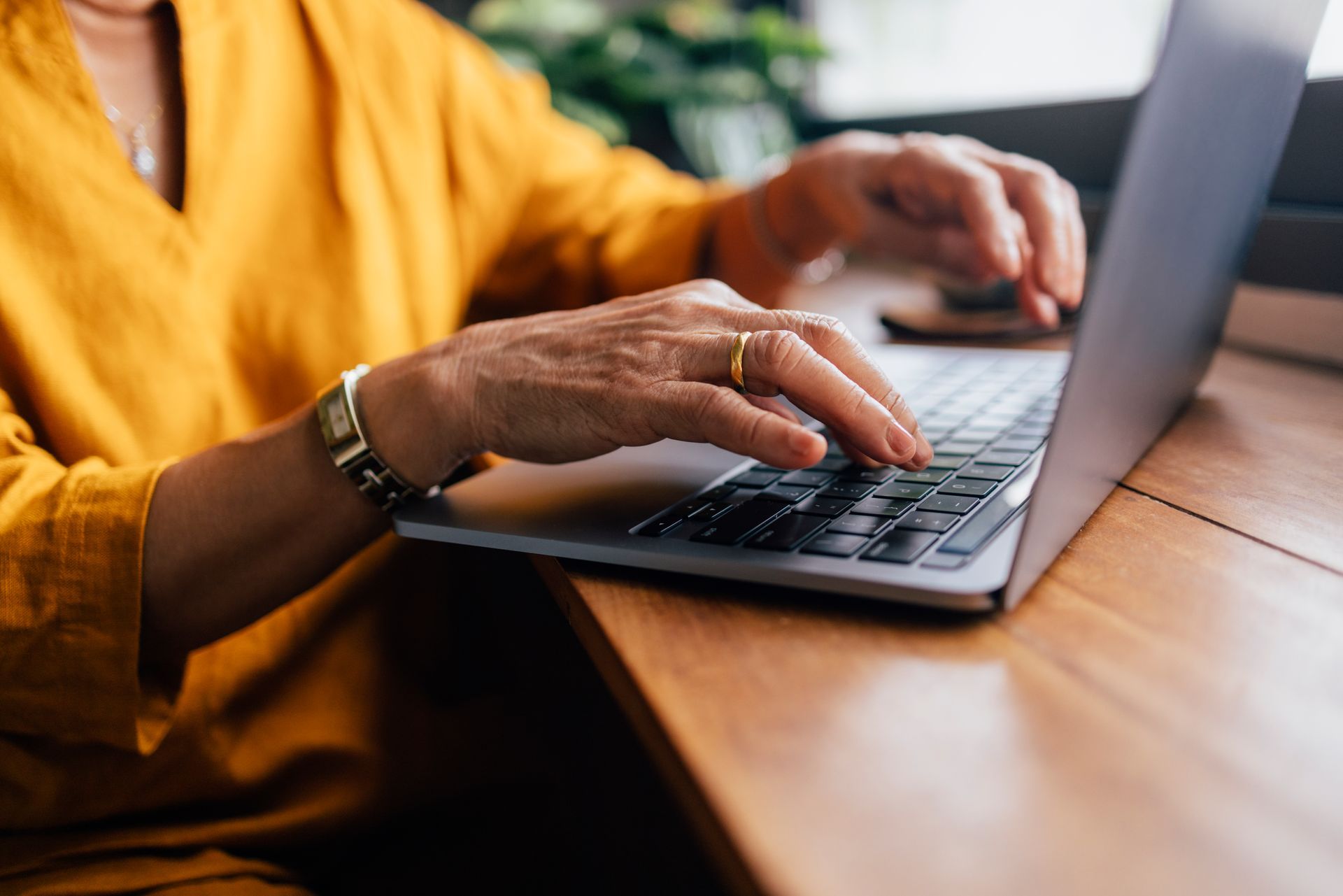Woman sitting at a table looking at her laptop
