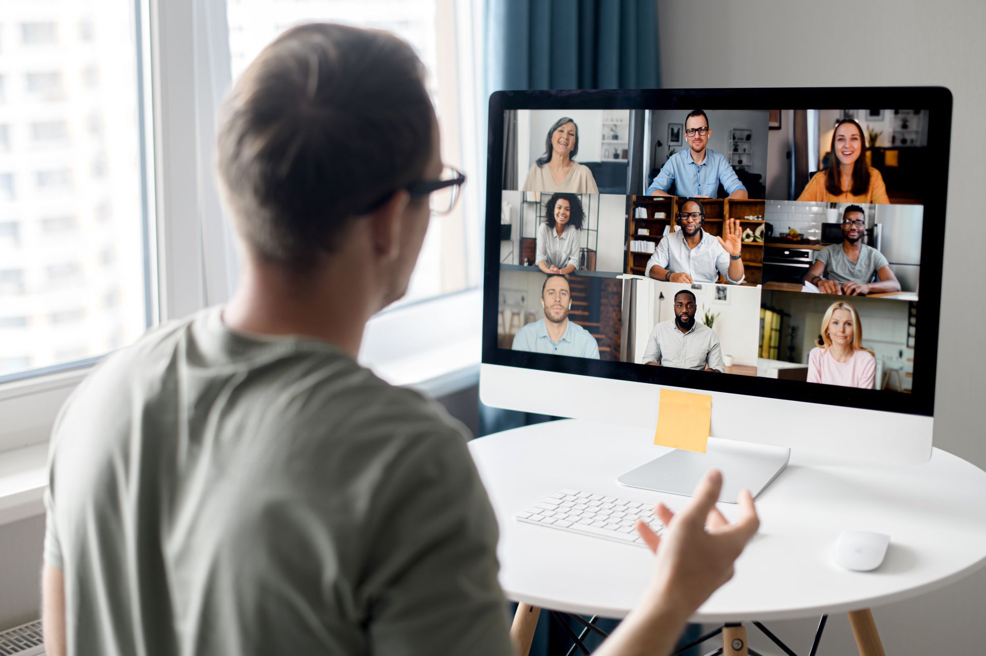 Man in glasses on video call with nine other people on a computer screen.