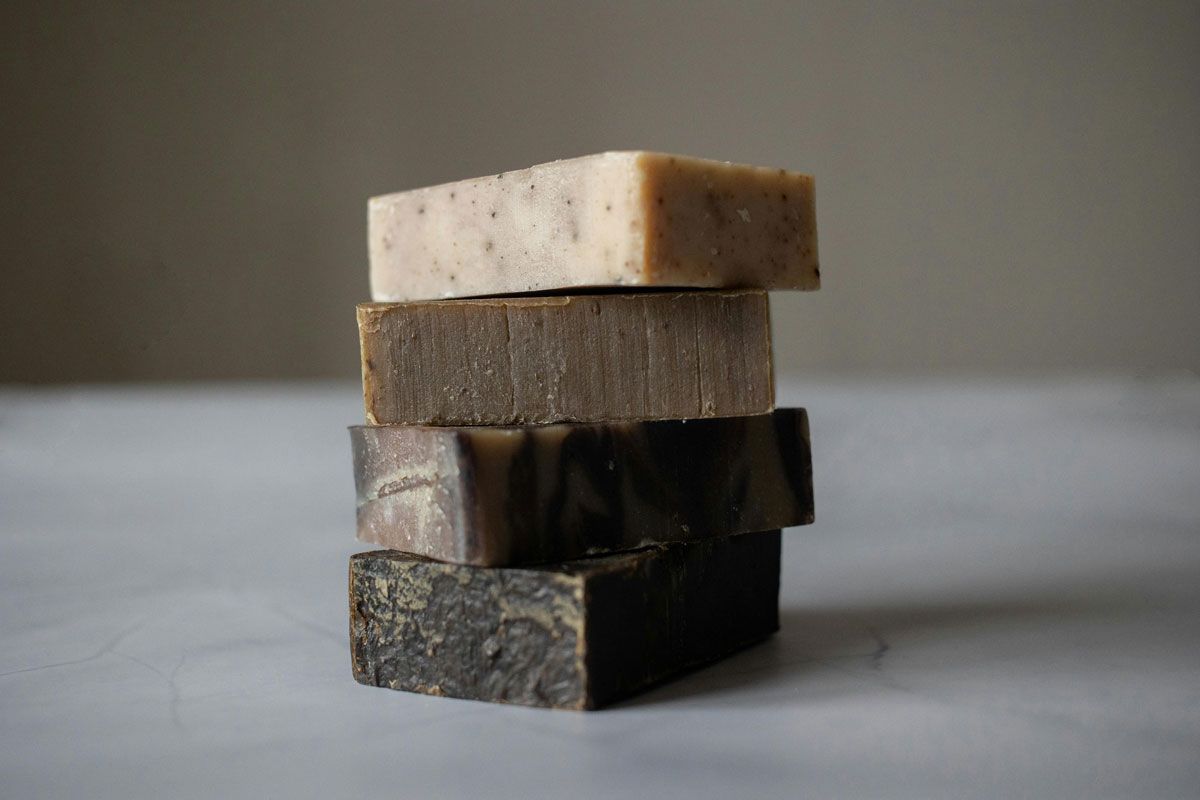 Four bars of soap are stacked on top of each other on a table.