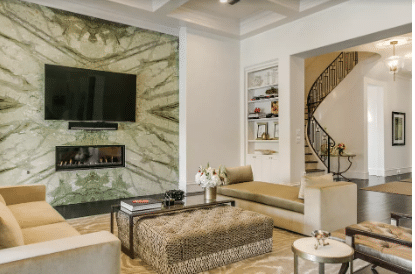 A living room with a fireplace and a flat screen tv on the wall.