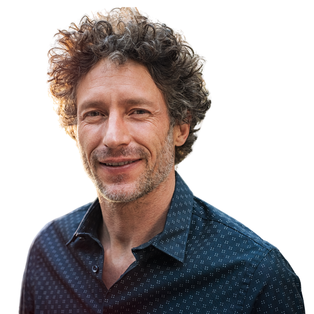 A man with curly hair and a beard wearing a blue shirt