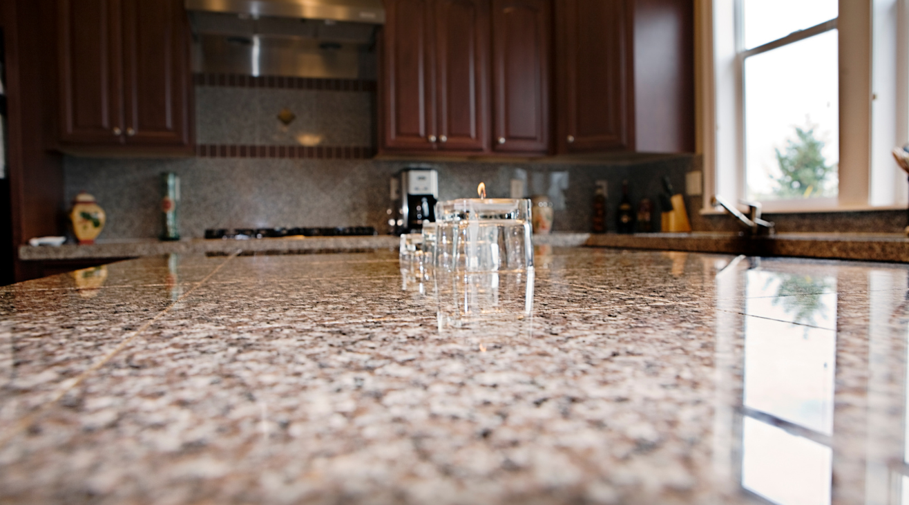 A kitchen counter with a lot of glasses on it.