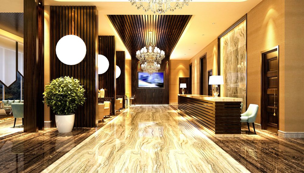 A lobby of a hotel with a chandelier hanging from the ceiling.