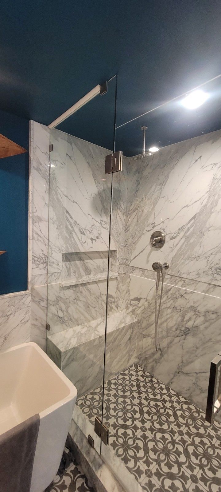 A bathroom with a walk in shower and a sink.