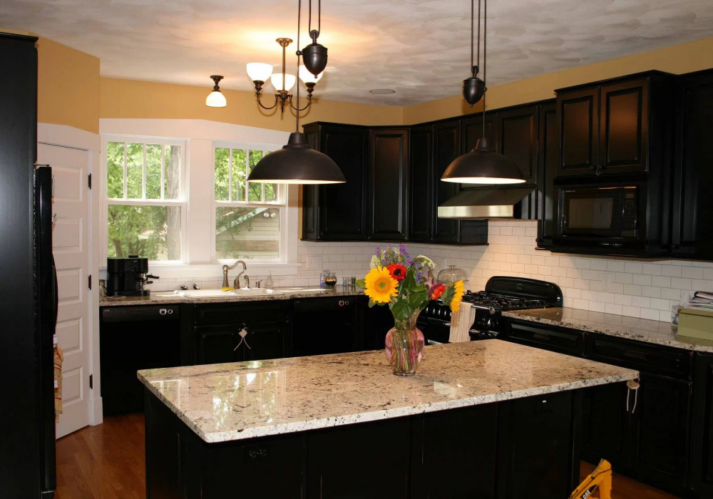A kitchen with black cabinets and granite counter tops
