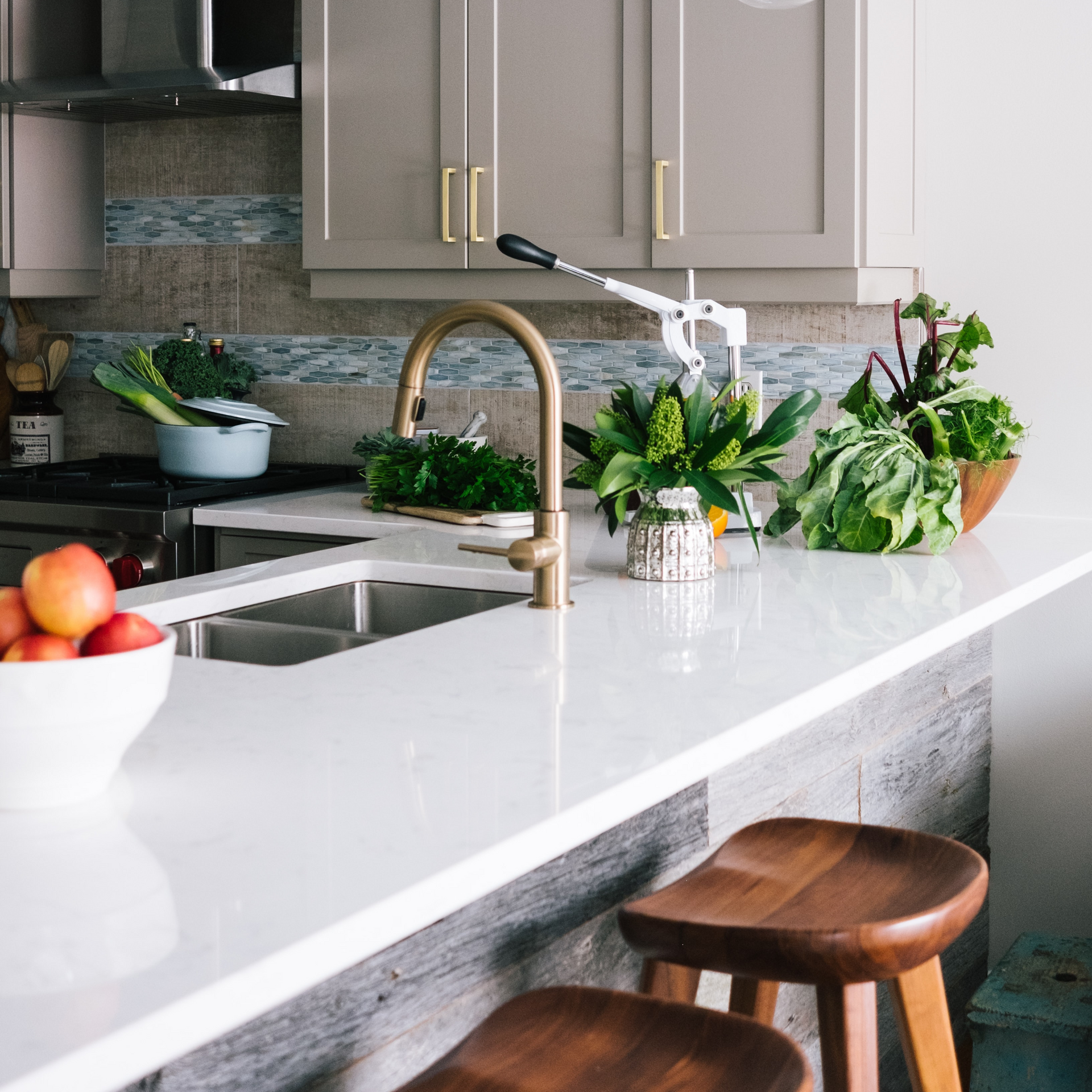 A kitchen with a sink and a bowl of fruit on the counter