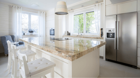 A kitchen with a stainless steel refrigerator and a granite counter top.