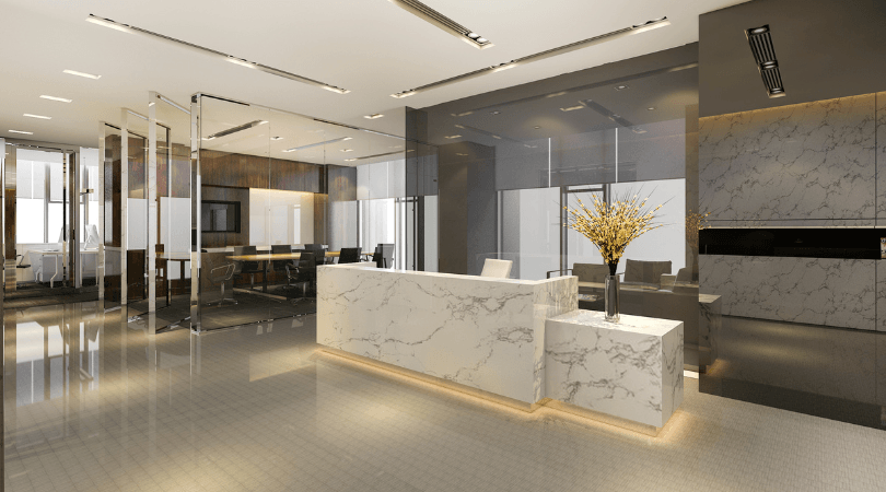 There is a marble reception desk in the middle of the room.