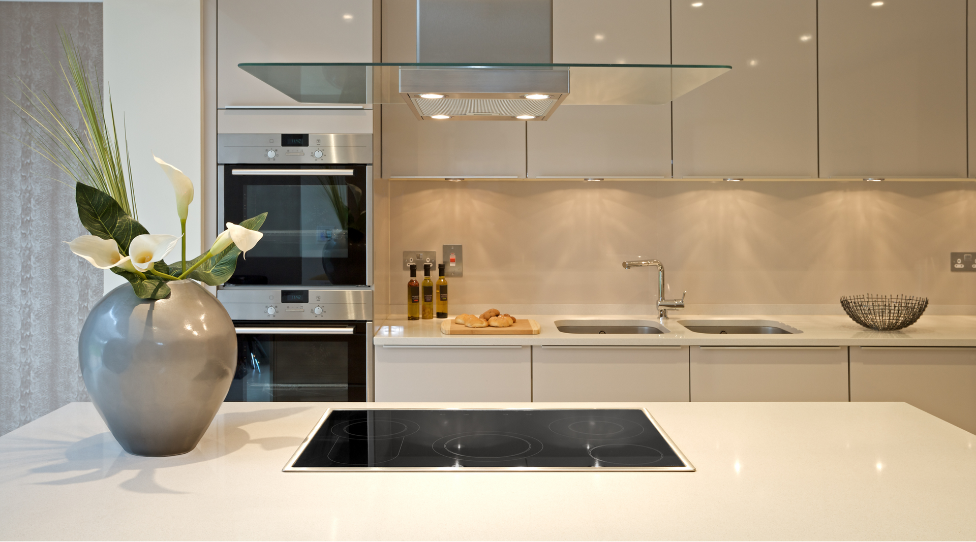 A kitchen with a vase of flowers on the counter and a stove top oven.