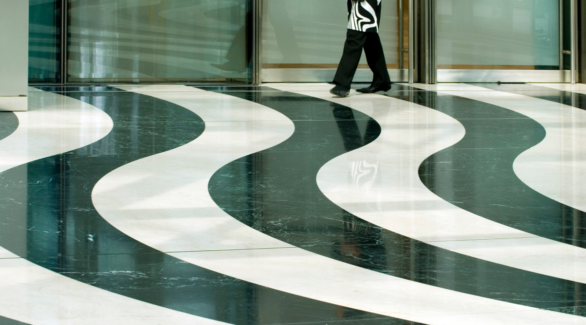 A person is walking on a black and white striped floor