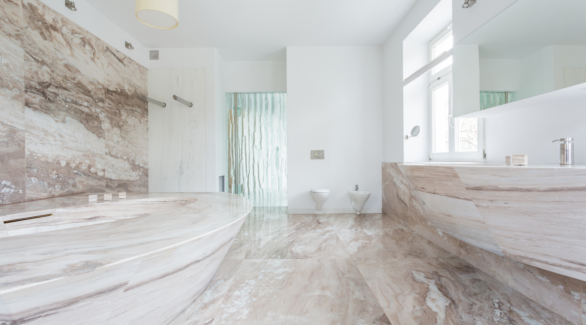 A bathroom with a tub , sink , toilet and mirror.