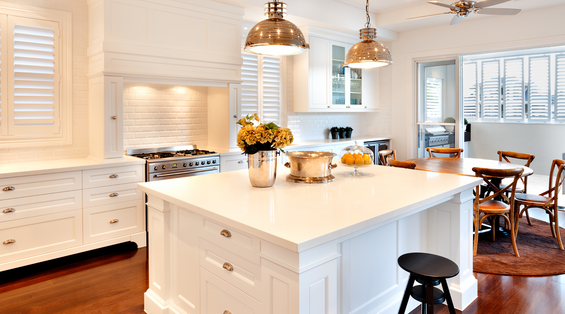 A kitchen with white cabinets and a large island in the middle