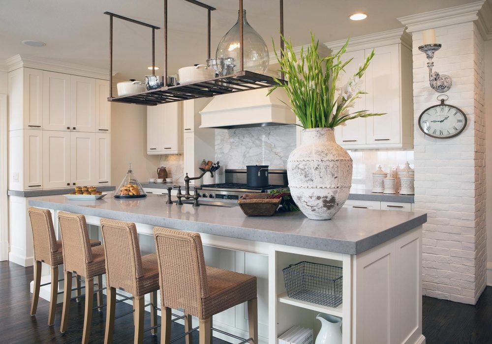 A kitchen with a large island and a clock on the wall.
