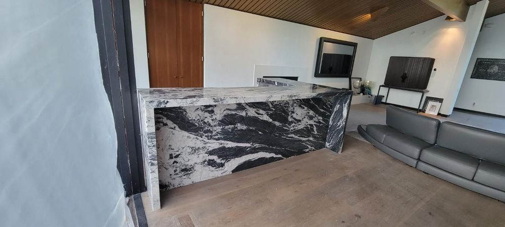 A living room with a marble counter top and a couch.