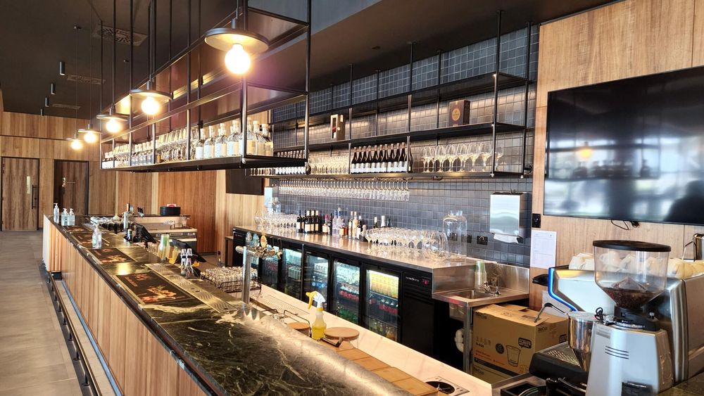 A long bar in a restaurant with a lot of glasses on it.