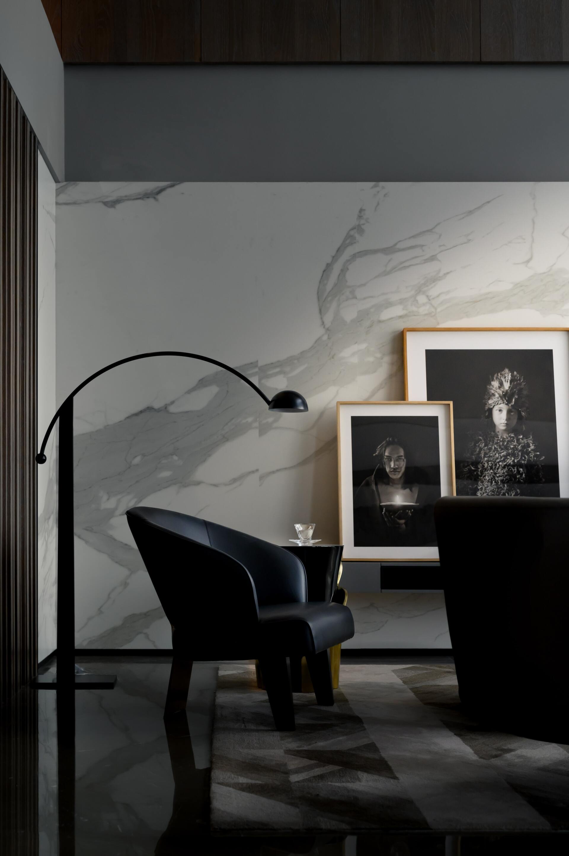 A living room with a black chair and a lamp