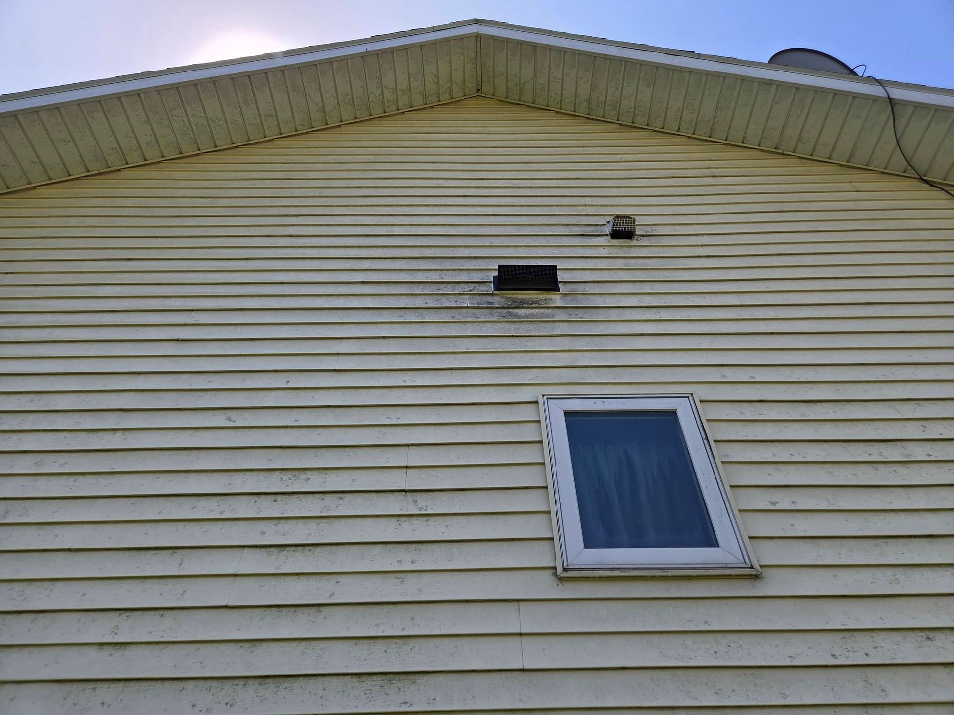 House siding with a slanted roof and a small window under the eaves