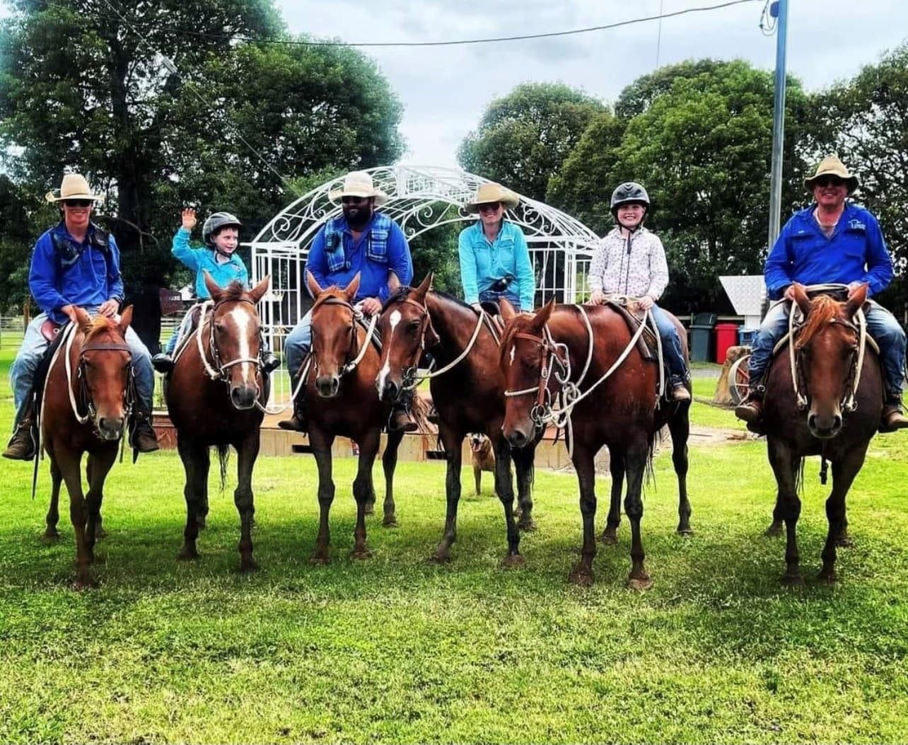 A group of people are riding horses in a field.