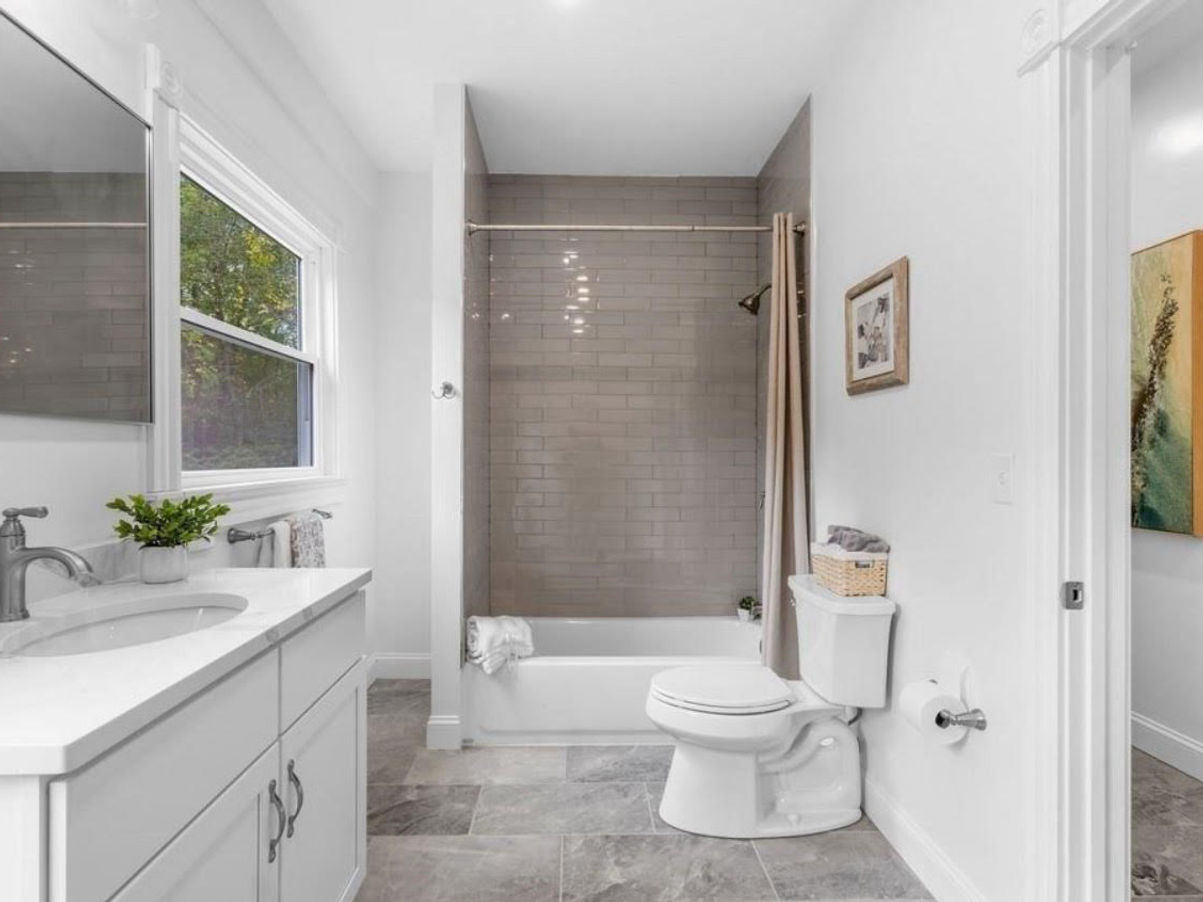 A bathroom with a toilet , sink , tub and shower.