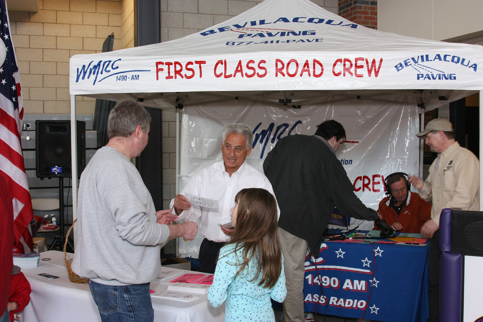 A group of people standing under a tent that says first class road crew