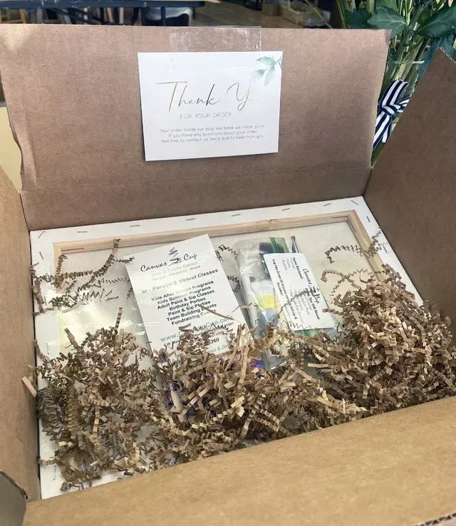 A box filled with shredded paper and a thank you card.