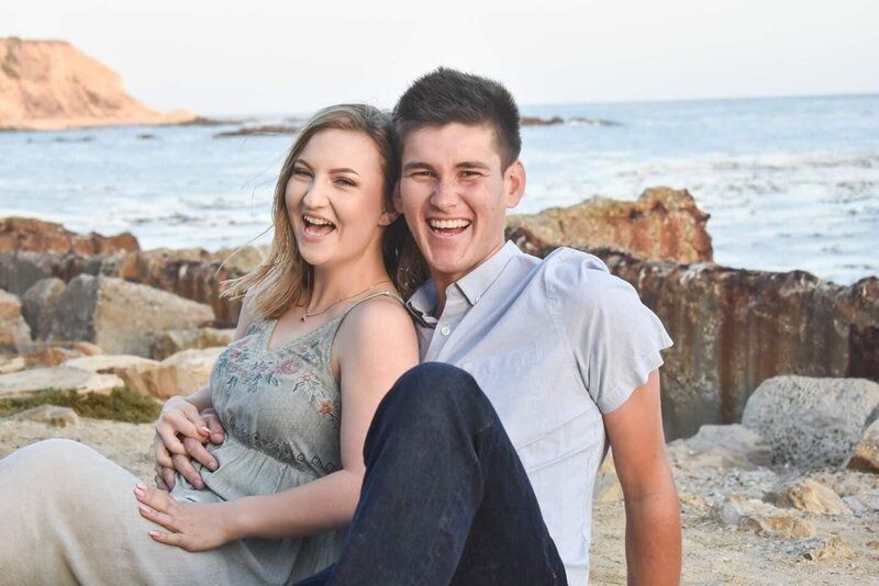 A man and a pregnant woman are sitting on the beach. Couples. White Point Beach.