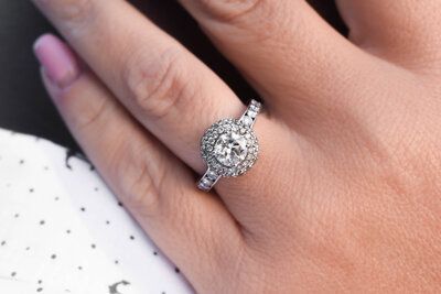 A woman is wearing a diamond ring on her left hand.