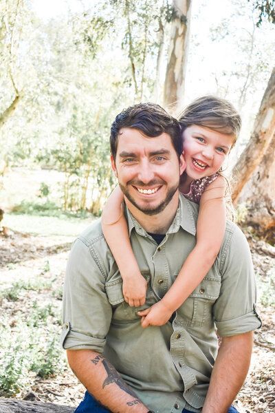 A man is carrying a little girl on his shoulders. Family. Daughter.