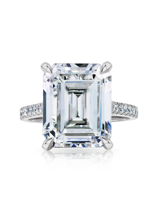 Emerald-cut diamond engagement ring with a pavé band on a white background Emerald-cut diamond engagement ring with a pavé band on a white background