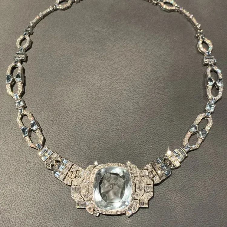 Silver necklace with large clear gemstone pendant on a gray background