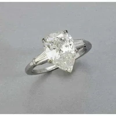 Silver ring with a large clear faceted gemstone on a gray background Silver ring with a large clear faceted gemstone on a gray background