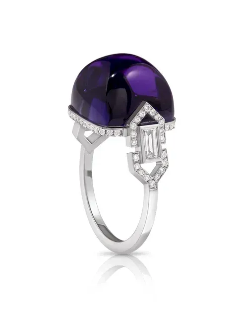 Silver ring with a large purple gemstone and geometric diamond accents