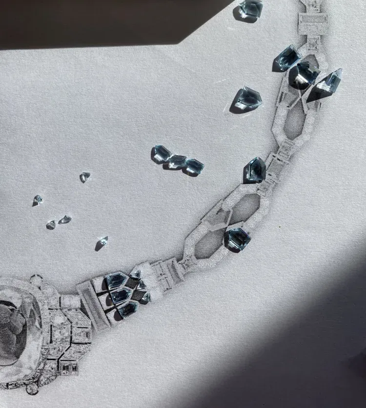 Silver chain bracelet with dark blue gems scattered on a white background
