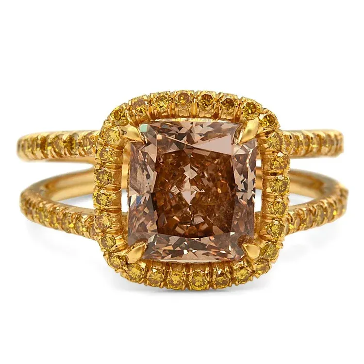 Gold ring with a brown cushion-cut center stone and a halo of small diamonds