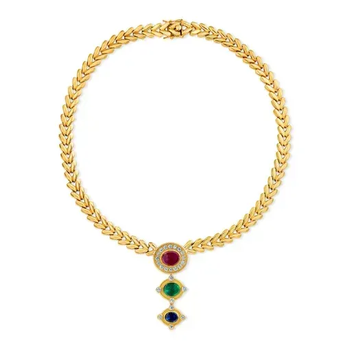 Gold necklace with a circular chain and three gemstone pendants in red, green, and blue