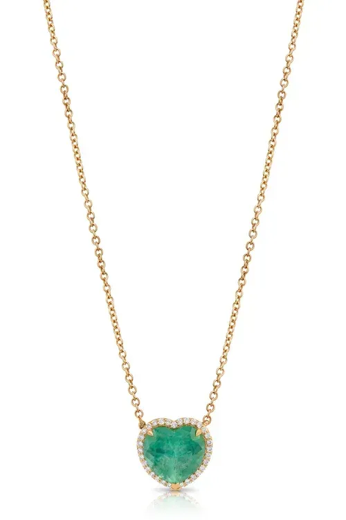 Gold necklace with a small green heart-shaped pendant and clear stones