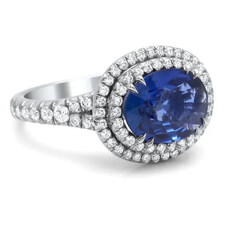 Silver ring with a round blue gemstone and halo of small diamonds