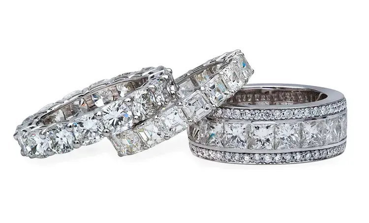 Three diamond-encrusted silver rings displayed together on a white background