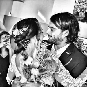 Bride and groom embrace during their wedding dance, smiling in black-and-white photo