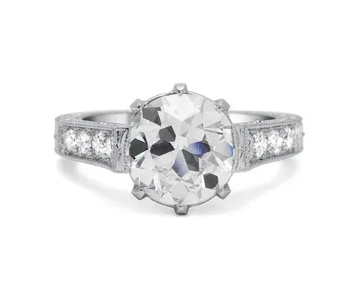 Round diamond solitaire engagement ring with a silver band and small side stones Round diamond solitaire engagement ring with a silver band and small side stones