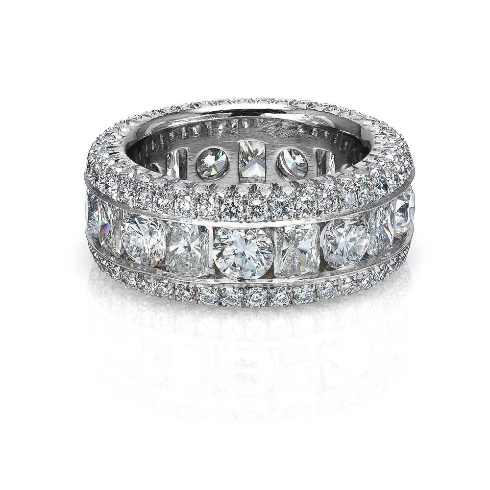 Diamond eternity band ring with rows of round and baguette-cut stones on a white background